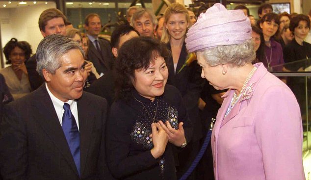 Британская королева Елизавета II справа, с фотографом Associated Press Ник Ут слева, и Фан Тхи Ким Фук в центре, в Лондоне в 2000 году