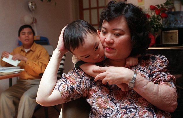25 мая 1997 года, Фан Тхи Ким Фук держит сына Томаса, 3 лет, в своей квартире в Торонто. Ее муж, Буй Зуй Тоан находится слева