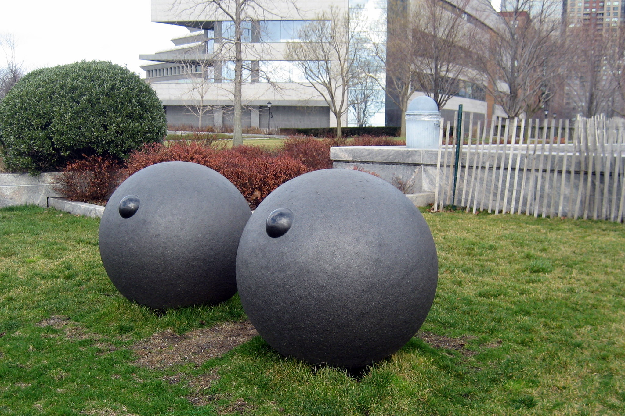 NYC - Battery Park City: Robert F. Wagner Park - Eyes Louise Bourgeois' 1995 "Eyes" marks a departure for the artist in that the subject, unlike previous treatments, is explored as two large units representing eyes separated from any suggested surrounding physiognomy. Resting directly on the ground a calculated distance from each other, they occupy considerable volumes of space between and around them which the viewer is invited to fill in with his or her own imagination. Thus a giant's head emerges in one's mind. The works are carved in granite with pupils suggested by large polished nodules. These are not inset but are an integral part of the whole granite "eyeball." The French-born Bourgeois has lived in New York for over half a century and is one of the most influential American artists of the past three decades. Her sculptures are known for their emotional immediacy, impressive workmanship and memorable symbolic imagery.