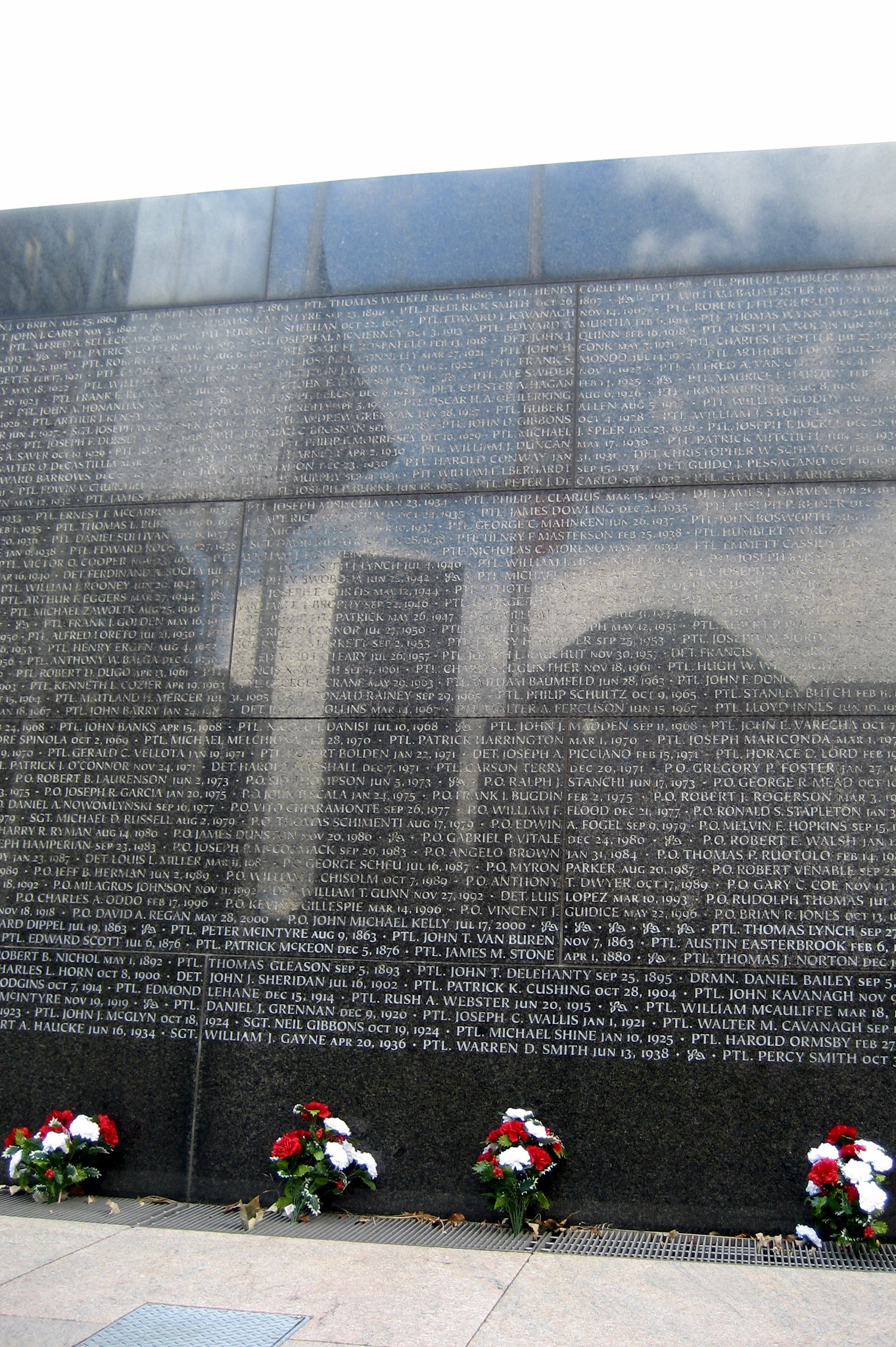 NYC - Battery Park City: Esplanade - New York City Police Memorial The design of the Stuart Crawford’s 1997 Police Memorial is composed of two distinct parts using water as a metaphor. A fountain serves as the genesis of the memorial and represents the rookie police officer's first day while a linear flume acts as the time line of the officer's career. Water flows gently over the spit face bottom of the flume leading to a slot in the granite wall. Finally the water comes to rest in a shallow pool marking the police officer's death. The death of the police officer is commemorated in an outdoor room defined by two parallel granite walls and depressed thirty inches below the esplanade. A wall along the western edge holds the names of the officers and dates on which they were killed. Constructed of green granite, the stone is rendered with a split face finish facing outward and polished surface facing inward reinforcing the sacred nature of the space. Outside the room three flagpoles stand as sentinels. Stuart Crawford has received the AlA Award for Excellence in the Study of Architecture and the Edward D. Stone Award for Excellence in Design. Crawford was chosen to design the Police Memorial from 180 submissions in an open design competition.