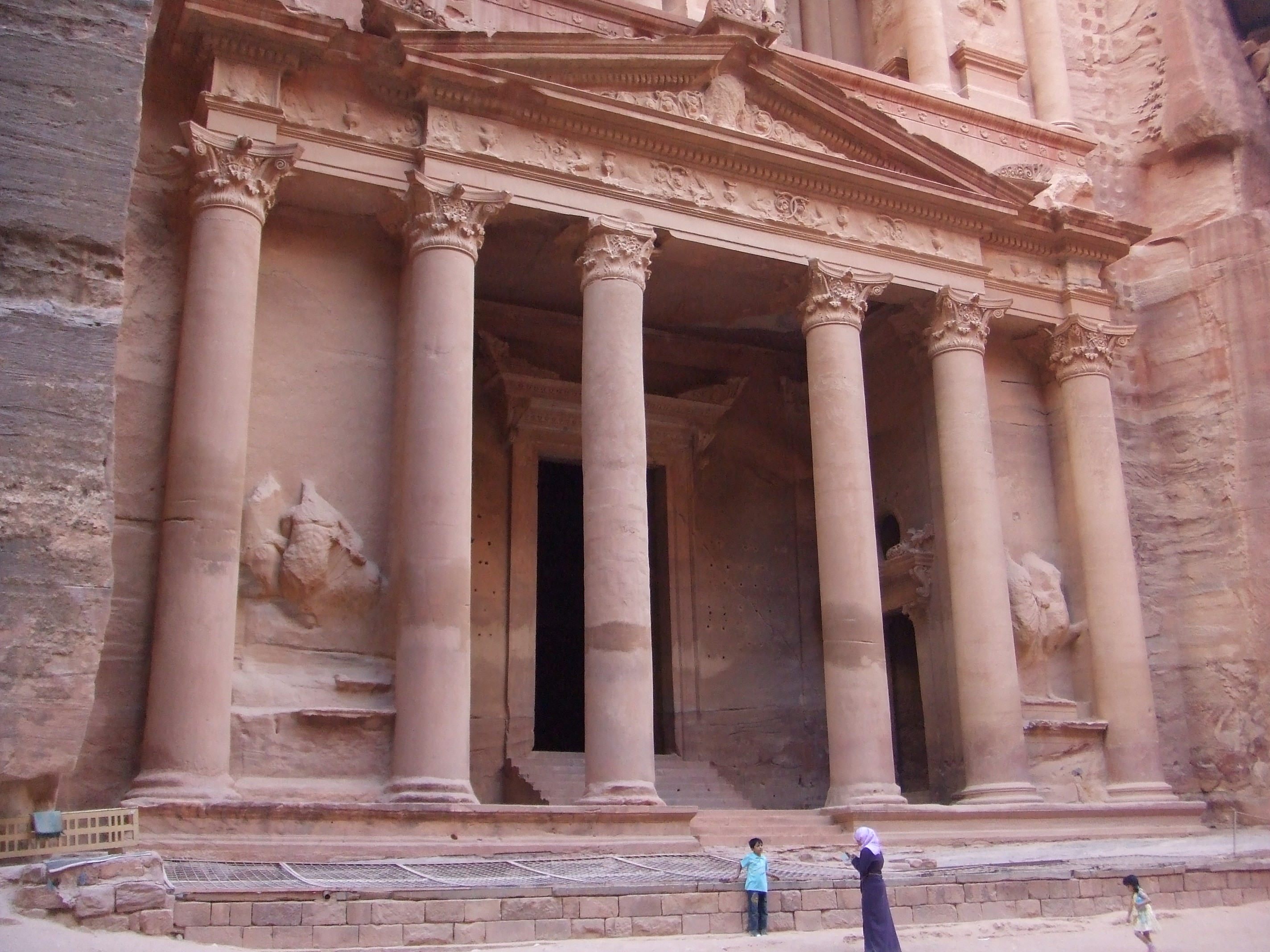 El Khazneh / The Treasury, Petra Petra's most famous monument is the first one encounters as a visitor (as well as the last seen upon exiting the site), dramatically revealed through the end of the Siq. The Treasury, known locally as El Khazneh, is an unforgettable sight. The façade is spectacular and one of the most perfectly preserved specimens of classical architecture surviving from Antiquity. It is believed to date from the 1st century BC and to have been conceived as a sepulchre for one of the Nabatean kings. Some consider it may have been used as a temple, though, like most of Petra's monuments, it's interior is quite small in relation to the stupendous façade, a mere chamber without decoration (which wasn't accessible to the public when we visited). The Treasury façade is also Petra's best preserved monument, being in a sheltered position, with much of the stonework looking as good as new. Sadly the extensive figurative sculpture has fared less well, having been systematically defaced by Islamic iconoclasts in the 8th century, but the dramatic poses of the dancing figures adorning the upper storey still add a touch of drama.