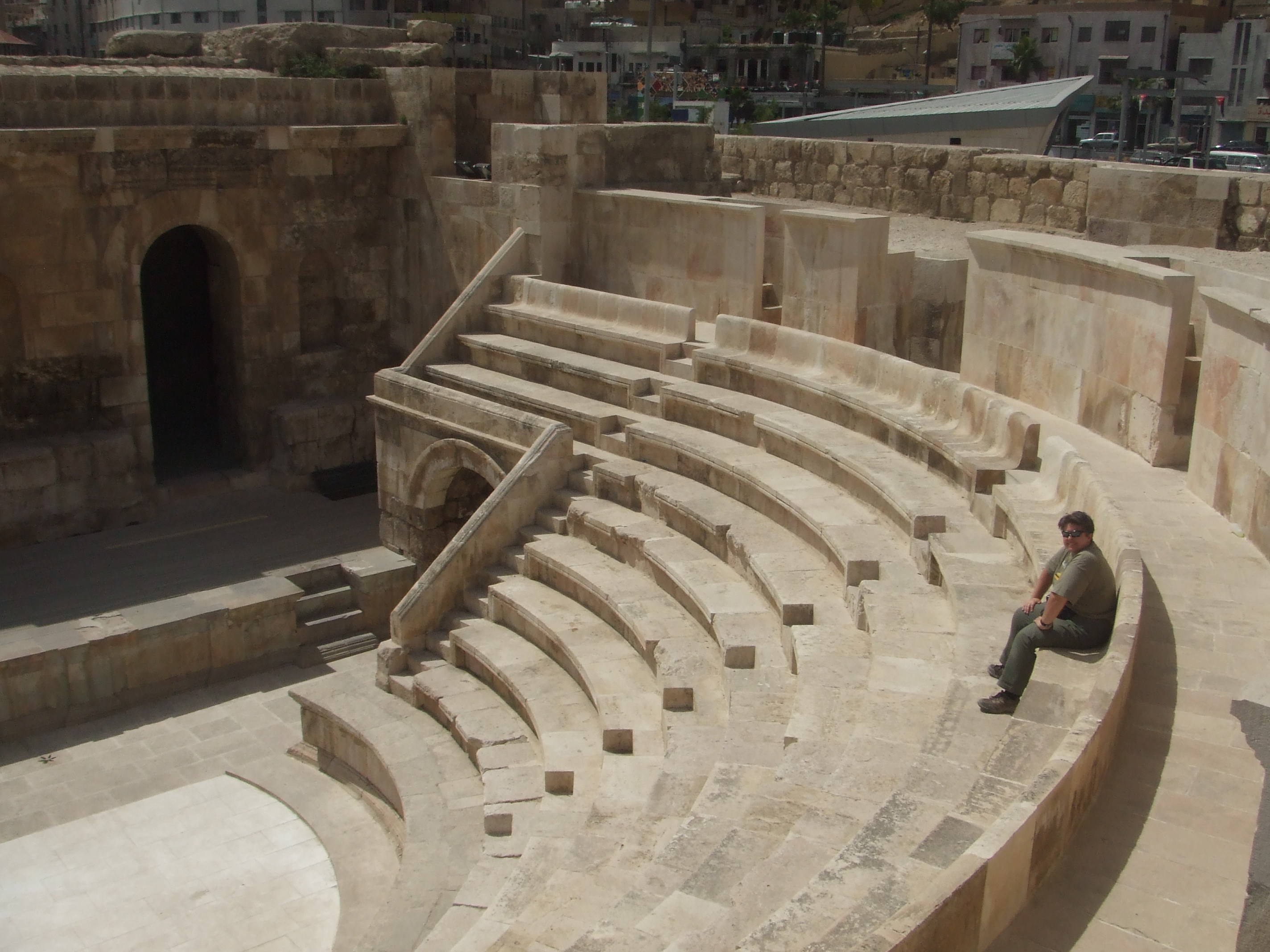 Odeon, Amman The Odeon sits in Hashemite Square adjacent to the much larger amphitheatre and accessible with the same ticket. Amman's city centre may have a modern feel today but is actually one of the oldest continuously inhabited cities in the World, with evidence of its classical past (as the ancient city of Philadelphia) still visible in certain areas. The most important remaining monument of the city's classical past is the stunning Roman amphitheatre. The theatre was built the reign of Antonius Pius (138-161 AD) and could seat up to 6,000 people. Built into the hillside, it was oriented north to keep the fierce sun off the spectators.