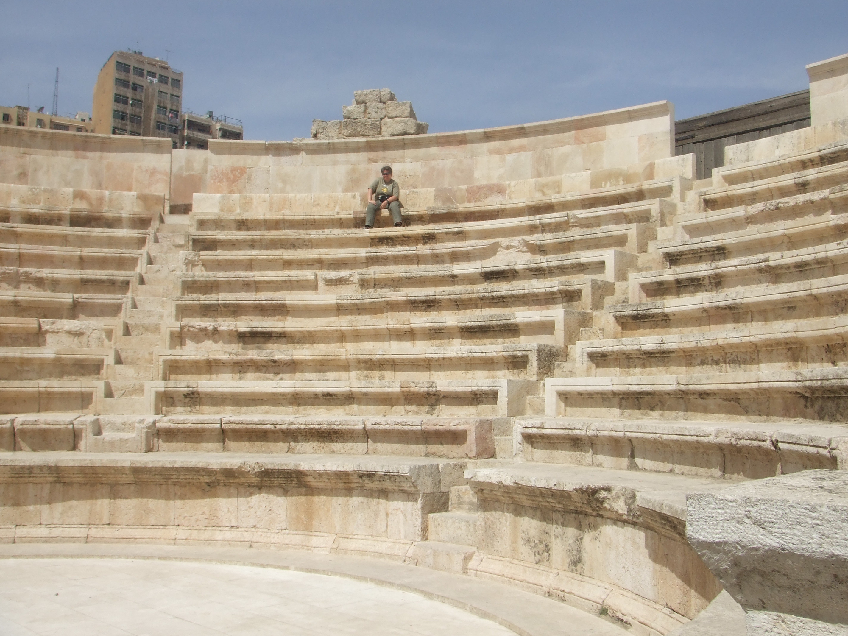 Odeon, Amman The Odeon sits in Hashemite Square adjacent to the much larger amphitheatre and accessible with the same ticket. Amman's city centre may have a modern feel today but is actually one of the oldest continuously inhabited cities in the World, with evidence of its classical past (as the ancient city of Philadelphia) still visible in certain areas. The most important remaining monument of the city's classical past is the stunning Roman amphitheatre. The theatre was built the reign of Antonius Pius (138-161 AD) and could seat up to 6,000 people. Built into the hillside, it was oriented north to keep the fierce sun off the spectators.
