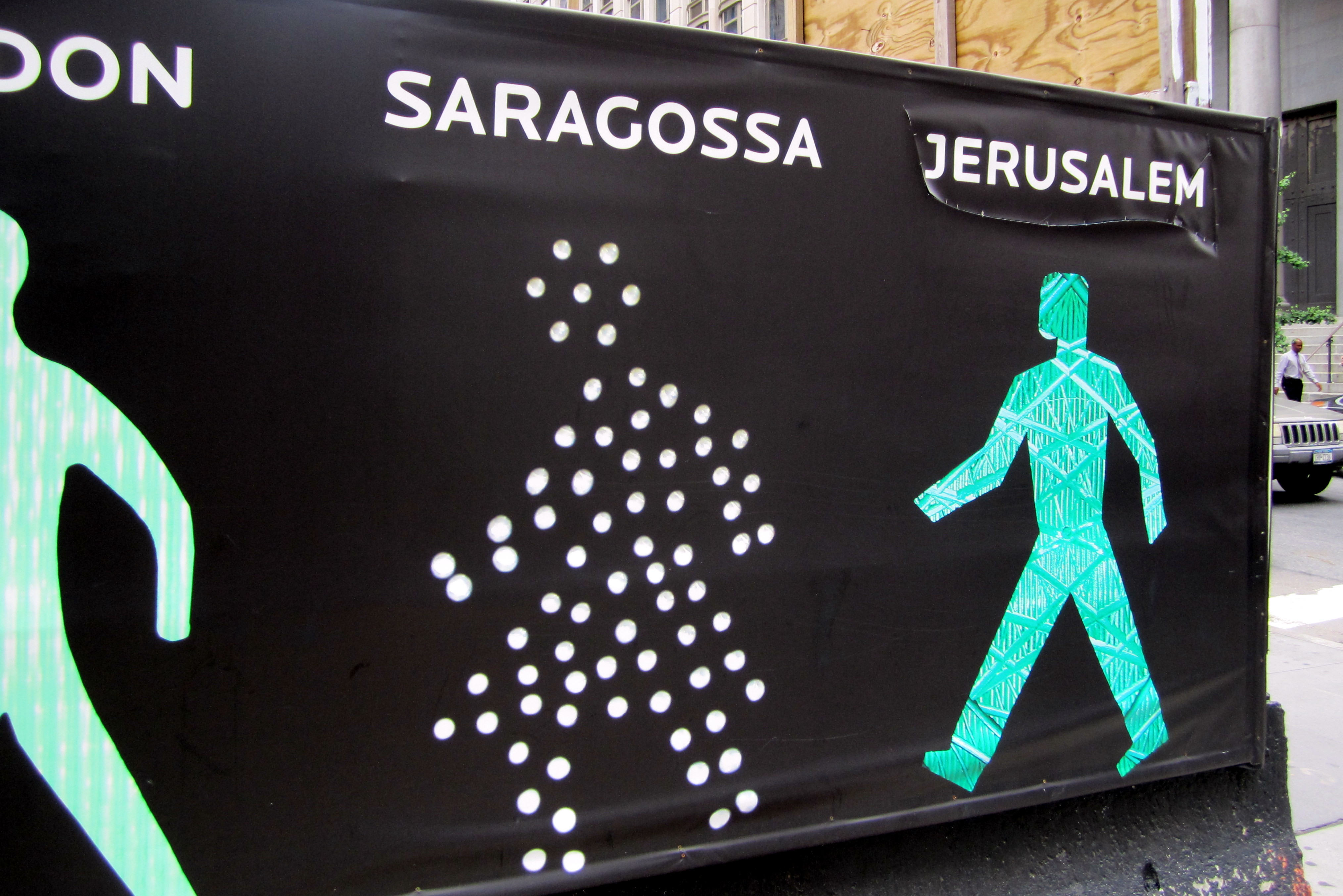 NYC - FiDi: Walking Men 99 Walking Men 99 is a site specific Public Art installation by artist Maya Barkai, surrounding the site of the planned Four Seasons Hotel, at 99 Church Street, in 2010. The photographic collage features 99 pedestrian traffic-light icons collected from around the world.