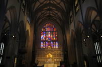 NYC - FiDi: Trinity Church Trinity Church, prominently located at the terminus of Wall Street at 79 Broadway, is the oldest Episcopal church in New York City, having been consecrated on Ascension Day May 1, 1846. Designed by architect Richard Upjohn, Trinity is considered a classic example of Gothic Revival architecture. At the time of its completion, the 281-foot spire was the highest point in New York until being surpassed in 1890 by the New York World Building. The Trinity Church parish received its initial charter from King William III of England in 1697. The first Trinity Church building, a modest rectangular structure with a gambrel roof and small porch was constructed in 1698. The building was destroyed in the Great New York City Fire of 1776, in the early days of the military occupation by the British during the American Revolutionary War. Construction on the second building began in 1788, which was consecrated in 1790 and then torn down after being weakened by severe snows during the winter of 1838–39. By the early 1840's, the church's expanding parish had split. The newly formed parish would build Grace Church, to the north on Broadway at 10th street, while the original parish would re-build the Trinity that stands today. Upjohn designed the new Church in Neo-Gothic fashion, complete with sandstone and stained-glass windows--two features unheard of at the time. Adorned with Gothic spires and pointed arches, and sporting a very linear upward-appearing exterior, the design reflected "High Church" fashion, at odds with contemporary Protestant "Low Church" thought. As a compromise, the side walls were kept simple, without the flying buttresses predominant in most Gothic structures. In 1876-1877 a reredos and altar was erected in memory of William Backhouse Astor, Sr., to the designs of architect Frederick Clarke Withers. In 1893, three sets of ornate hevy bronze doors, the Astor Memorial doors, conceived by Richard Morris Hunt and sculpted by J. Massey Rhind, Karl Bitter and Charles Henry Niehaus, were added. The adjoining Trinity Churchyard Cemetery, opened in 1697, is one of three separate burial grounds that make up the non-denominational Trinity Church Cemetery (the others being the Churchyard of St. Paul's Chapel and the Trinity Church Cemetery and Mausoleum at the Chapel of Intercession). Among the 1,186 interred here are Alexander Hamilton, William Bradford, Robert Fulton (memorial tribute), Captain James Lawrence, Horatio Gates, and Albert Gallatin. There are also memorials to the unknown martyrs of the Revolution buried on the grounds, 16 officers of the Continental Army and Navy buried in the church cemeteries, and to the thousands of Americans who died in prison ships in New York Harbor. Trinity Church and Graveyard was designated a landmark by the New York Landmarks Preservation Commission in 1966. National Register #76001252 (1982)