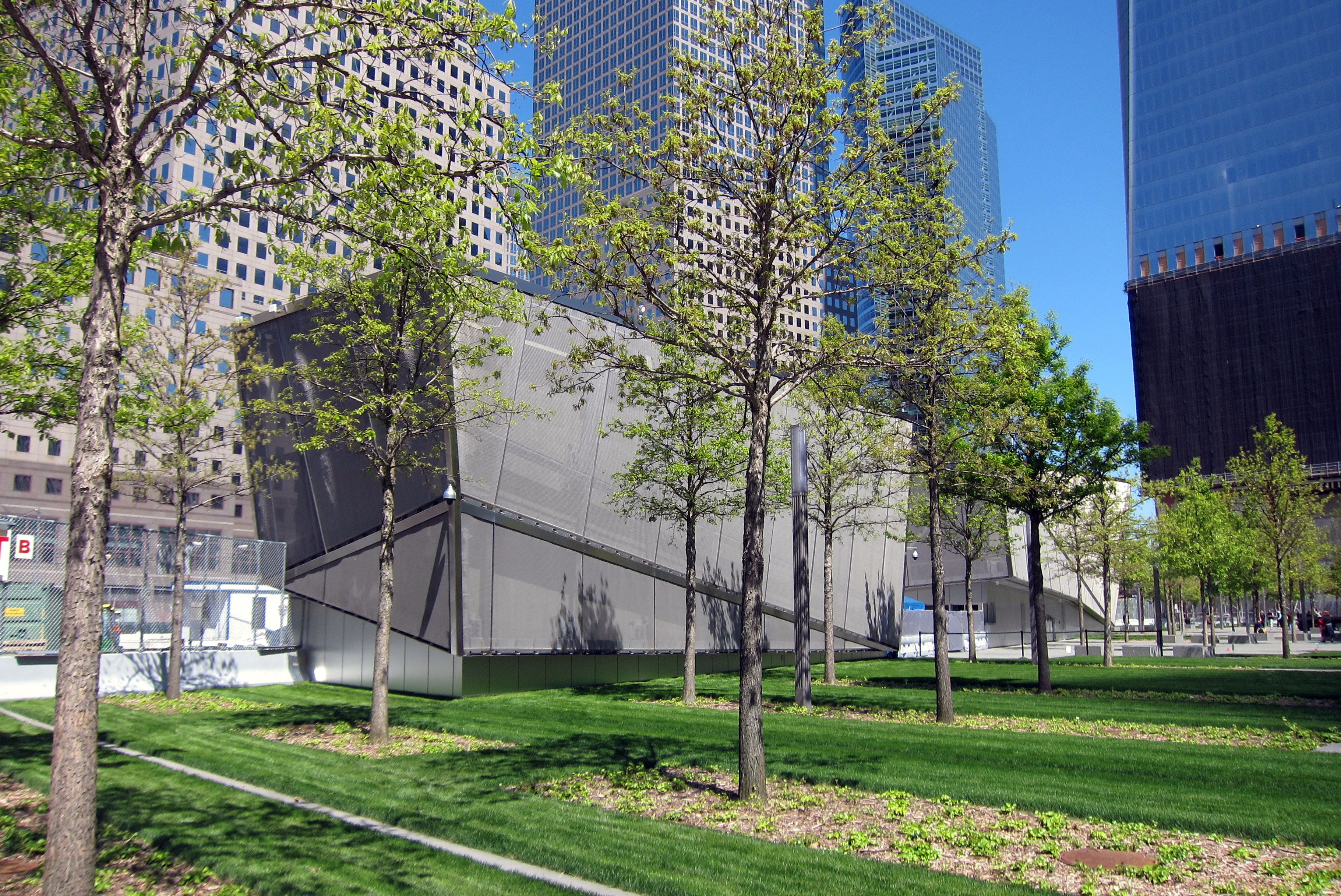 NYC: National September 11 Memorial The National September 11 Memorial & Museum, located on 6-acres of the World Trade Center site, is a tribute of remembrance and honor to the 2,983 men, women and children killed in the terror attacks of September 11, 2001 at the World Trade Center site, near Shanksville, Pa., and at the Pentagon, as well as the six people killed in the World Trade Center bombing in February 1993 The National September 11 Memorial, designed by American architect Michael Arad of Handel Architects in conjunction with landscape architecture firm Peter Walker and Partners, was formally dedicated on September 11, 2011, commemorating the tenth anniversary of the attacks. Arad and Walker's design was selected from 5,201 entries in an open, international memorial contest, initiated by the Lower Manhattan Development Corporation (LMDC), as per the specifications of architect Daniel Libeskind. Two reflecting pools, each about an acre in size with 30-foot waterfalls--the largest manmade in waterfalls in North America--cascading down their sides, are set within the footprints of the original Twin Towers. The names of 2,983 victims are in inscribed on 76 bronze plates attached to the parapet walls that form the edges of the memorial pools, arranged based on "meaningful adjacencies"--an algorithm developed by Local Projects which includes proximity at the time of the attacks, company or organization affiliations for those who worked at the World Trade Center or Pentagon, and approximately 1,200 requests from family members. The Memorial Plaza surrounding the pools provides a contemplative escape, with a grove of more than 400 swamp white oak trees, each selected from nurseries within a 500-mile radius of the three attack sites. A small clearing in the grove, known as the Memorial Glade, designates a space for gatherings and special ceremonies. The National September 11 Memorial Museum Pavilion, designed by Craig Dykers and Kjetil Thorsen of Snøhetta, is scheduled to open on or around September 11, 2012. The museum will feature over 110,000 square feet of exhibition space telling the story of the 9/11 through multimedia displays, archives, narratives and a collection of monumental and authentic artifacts.