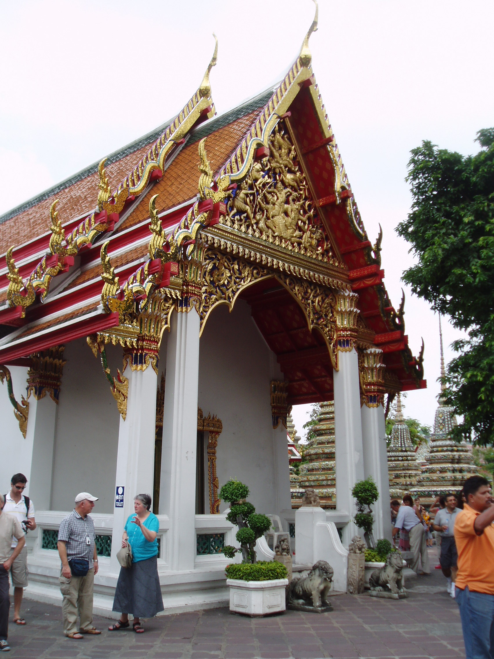 Wat Pho, Bangkok Wat Pho is the largest and oldest temple complex in Bangkok, and along with the temmple of the royal palace the most visited. The sprawling complex covers a huge area and it is quite easy to lose oneself within it's series of courtyards, gateways and stunning temple buildings. The present complex largely dates back to 1788, having been founded in response to the sacking of the former capital Ayutthaya by the Burmese in 1767 where a similar complex was destroyed. It is known as a place of learning and has a renowned school of Thai massage within the site. The temple complex is entered through one of many gateways guarded by huge Chinese statues, believed to have been imported as ballast on ships trading with China..The outer gates have fierce warrior figures, whilst the inner courtyards have the bizarre 'farang' ('foreigner') figures with their peculiar 'top hats', believed to represent the first European visitors to the east. Many of the inner courtyards are surrounded by a cloister containing over 400 sculptures of the seated Buddha, whilst the main Bot, the spiritual nucleus of the temple, is beautifully decorated within with frescoes of rich landscapes in red and gold. The biggest and most spectacular attraction of the temple however is the Hall of the Reclining Buddha, housing an enormous gilded recumbent figure of the Buddha over 160ft long, filling the entire centre of the chamber. en.wikipedia.org/wiki/Wat_Pho