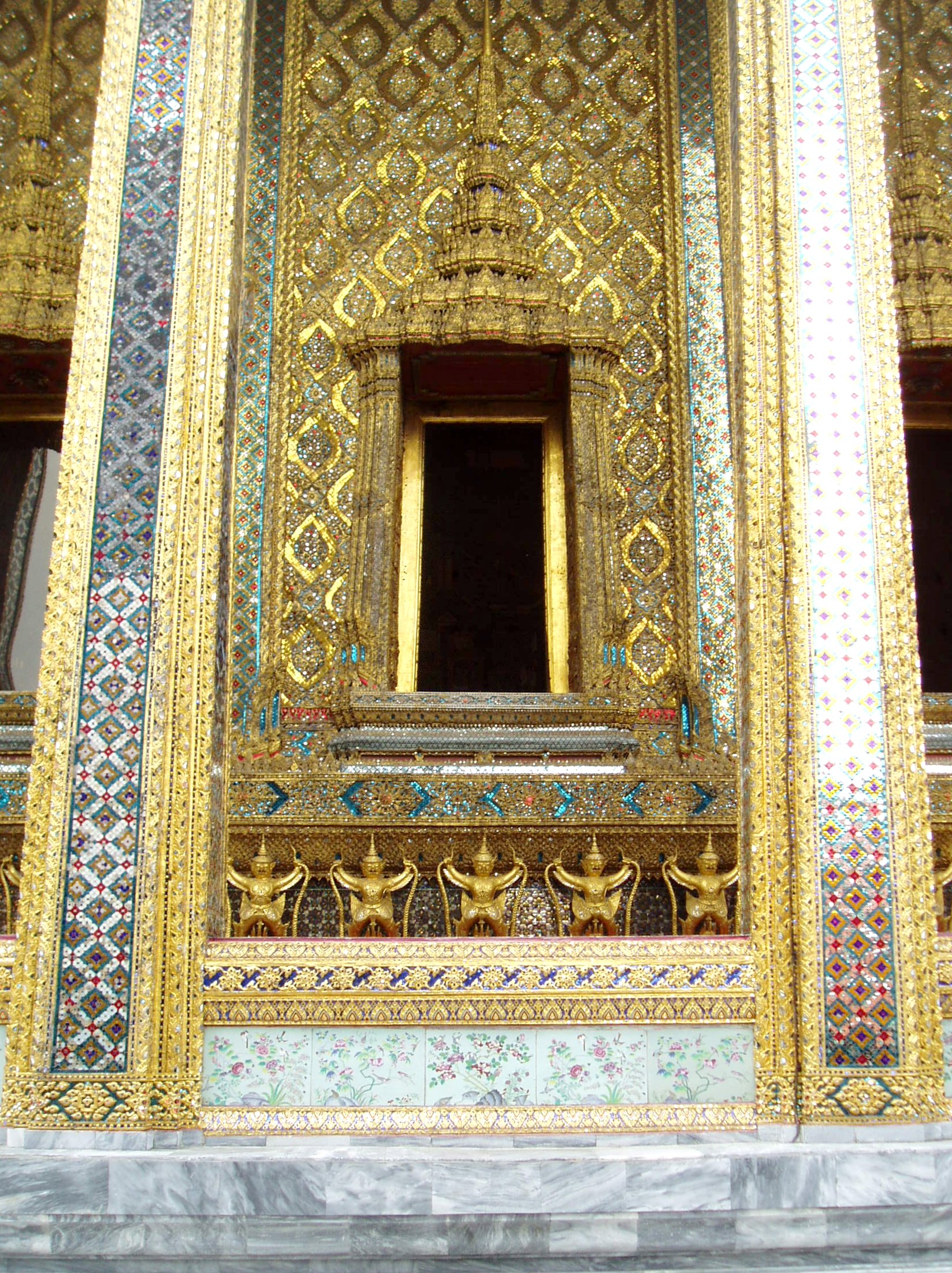 Emerald Buddha Temple, Wat Phra Kaew, Bangkok Bangkok's most unmissable attraction is of course the Grand Palace, and most specifically the temple complex of Wat Phra Kaew (Temple of the Emerald Buddha), famed for it's riot of coloured and gilded ornament, paintings and sculptures; quite simply, so visually stunning there is nothing quite like it anywhere else! The Palace and Temple complex were begun in 1782, the year the capital was moved to Bangkok, and parts of the palace buildings betray 18th century European influence combined with traditional Thai style, such as the breathtaking gilt spires on the roof. Most of the interiors of the Palace itself are off limits to visitors since, although no longer the main residence of the thai monarchy, it is frequently used for state functions and ceremonies. The Wat Phra Kaew complex however is the greatest draw, famed for it's stunning architecture and the famous 'Yaksha' guardian figures that flank all the main entrances to the complex. These towering figures, with their rich colours and tapering crowns, represent demonic characters from the mythological epic the 'Ramakien', and are identifiable as distinct individuals, all here serving a benign, protective role. The Ramakien is also the subject for a stunning sequence of wall paintings within the cloister that encirlces the entire site, illustrating in minute detail the battles of the heroic monkey warriors, led by the monkey god Hanuman, against the demonic armies and kingdoms of Tosakan. The Temple of the Emerald Buddha itself forms the largest structure and contains the venerated (though small) Buddha image. The complex contains several other iconic buildings clad in sumptuous decor, most notably the library or 'mondop' with it's gilt spire along with the great golden stupa. The temple complex is technically a royal chapel rather than a working monastery like most Thai temples as it has no resident monks (the sheer volume of visitors leaves little room for anyone else anyway!). en.wikipedia.org/wiki/Wat_Phra_Kaew en.wikipedia.org/wiki/Grand_Palace