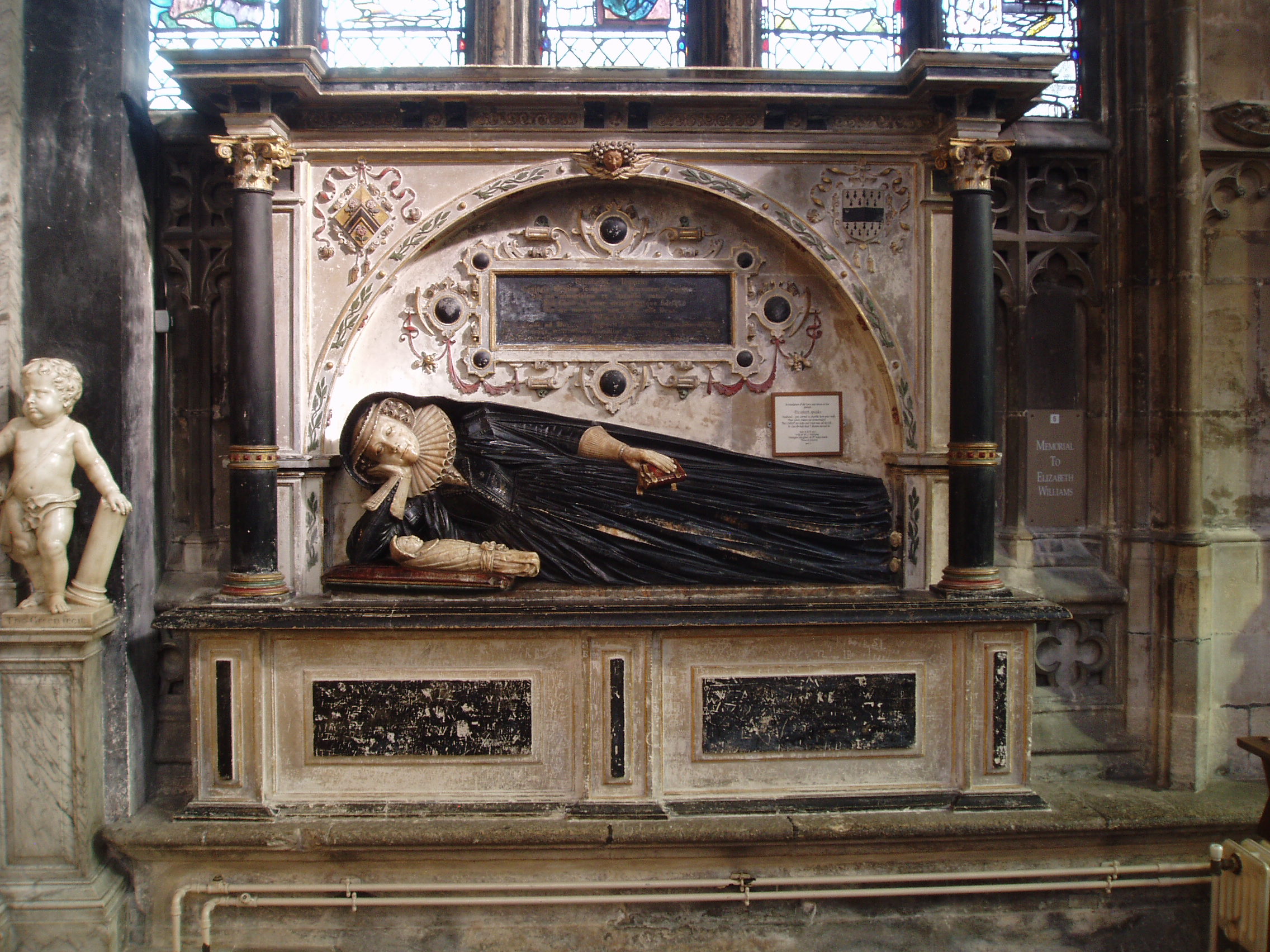 Elizabeth Williams Tomb Monument to Elizabeth Williams (a daughter of Bishop Miles) and her stillborn infant, erected in the early 17th century on the north side of the Lady Chapel at Gloucester Cathedral. Gloucester Cathedral is one of England's finest churches, a masterpiece of medieval architecture consisting of a uniquely beautiful fusion of Norman Romanesque and Perpendicular Gothic from the mid 14th century onwards. Until the Reformation this was merely Gloucester's Abbey of St Peter, under Henry VIII it became one of six former monastic churches to be promoted to cathedral status, thus saving the great church from the ravages of the Dissolution. The most obviously Norman part is the nave, immediately apparent on entering the building with it's round arches and thick columns (the exterior is the result of Gothic remodelling). Much of the remainder of the building is substantially the Norman structure also, but almost entirely modified in the later Middle Ages inside and out, the result of the great revenue brought to the abbey by pilgrims to the tomb of the murdered King Edward II in the choir. It was this transformation of the Norman church that is credited with launching the late gothic Perpendicular style in England. The gothic choir is a unique and spectacular work, the walls so heavily panelled as to suggest a huge stone cage (disguising the Norman arches behind) crowned by a glorious net-like vault adorned with numerous bosses (those over the Altar with superb figures of Christ and angels) whilst the east wall is entirely glazing in delicate stone tracery, and still preserving most of it's original 14th century stained glass. The soaring central tower, also richly panelled with delicate pinnacles, is another testament to the abbey's increasing wealth at this time. The latest medieval additions to the church are equally glorious, the Lady Chapel is entered through the enormous east window and is itself a largely glazed structure, though the original glass has been reduced to a few fragments in the east window, the remainder now contains beautiful Arts & Crafts stained glass by Christopher and Veronica Whall. The early 16th century cloisters to the north of the nave are some of the most beautiful anywhere, being completely covered by exquisite fan vaulting, with a seperate lavatorium (washing room) attached to the north walk as a miniature version of the main passages. There is much more of interest, from 14th century choir stalls with misericords to the comprehensive collection of tombs and monuments of various dates, including the elaborate tomb of Edward II and that of Robert Duke of Normandy, eldest son of William the Conqueror. The stained glass also represents all ages, from the 14th century to the striking contemporary windows by Tom Denny. Further areas of the cathedral can be accessed at certain times, such as the Norman crypt under the choir and the triforium gallery above. My visit coincided with the major 'Crucible' exhibition of contemporary sculpture (September-October 2010), examples of which I will upload in due course.