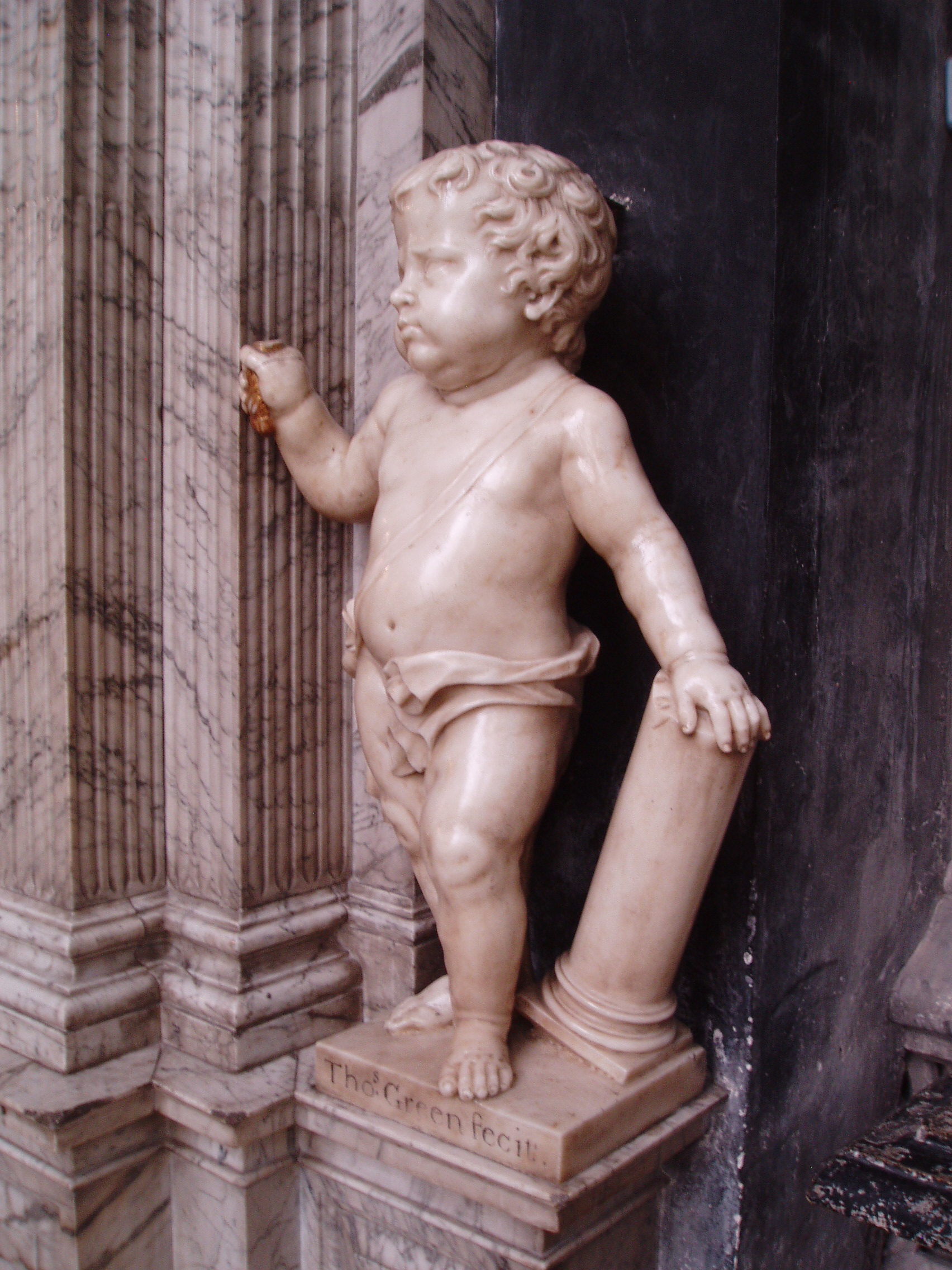 Putto with Green's Signature Monument to Judge John Powell carved in 1713 by Thomas Green of Camberwell, and situated on the north side of the Lady Chapel at Gloucester Cathedral. Impressive though the monument may be, it's installation was without sensitivity to the surrounding architecture and must have involved considerable cutting away of the late gothic stonework. Gloucester Cathedral is one of England's finest churches, a masterpiece of medieval architecture consisting of a uniquely beautiful fusion of Norman Romanesque and Perpendicular Gothic from the mid 14th century onwards. Until the Reformation this was merely Gloucester's Abbey of St Peter, under Henry VIII it became one of six former monastic churches to be promoted to cathedral status, thus saving the great church from the ravages of the Dissolution. The most obviously Norman part is the nave, immediately apparent on entering the building with it's round arches and thick columns (the exterior is the result of Gothic remodelling). Much of the remainder of the building is substantially the Norman structure also, but almost entirely modified in the later Middle Ages inside and out, the result of the great revenue brought to the abbey by pilgrims to the tomb of the murdered King Edward II in the choir. It was this transformation of the Norman church that is credited with launching the late gothic Perpendicular style in England. The gothic choir is a unique and spectacular work, the walls so heavily panelled as to suggest a huge stone cage (disguising the Norman arches behind) crowned by a glorious net-like vault adorned with numerous bosses (those over the Altar with superb figures of Christ and angels) whilst the east wall is entirely glazing in delicate stone tracery, and still preserving most of it's original 14th century stained glass. The soaring central tower, also richly panelled with delicate pinnacles, is another testament to the abbey's increasing wealth at this time. The latest medieval additions to the church are equally glorious, the Lady Chapel is entered through the enormous east window and is itself a largely glazed structure, though the original glass has been reduced to a few fragments in the east window, the remainder now contains beautiful Arts & Crafts stained glass by Christopher and Veronica Whall. The early 16th century cloisters to the north of the nave are some of the most beautiful anywhere, being completely covered by exquisite fan vaulting, with a seperate lavatorium (washing room) attached to the north walk as a miniature version of the main passages. There is much more of interest, from 14th century choir stalls with misericords to the comprehensive collection of tombs and monuments of various dates, including the elaborate tomb of Edward II and that of Robert Duke of Normandy, eldest son of William the Conqueror. The stained glass also represents all ages, from the 14th century to the striking contemporary windows by Tom Denny. Further areas of the cathedral can be accessed at certain times, such as the Norman crypt under the choir and the triforium gallery above. My visit coincided with the major 'Crucible' exhibition of contemporary sculpture (September-October 2010), examples of which I will upload in due course.