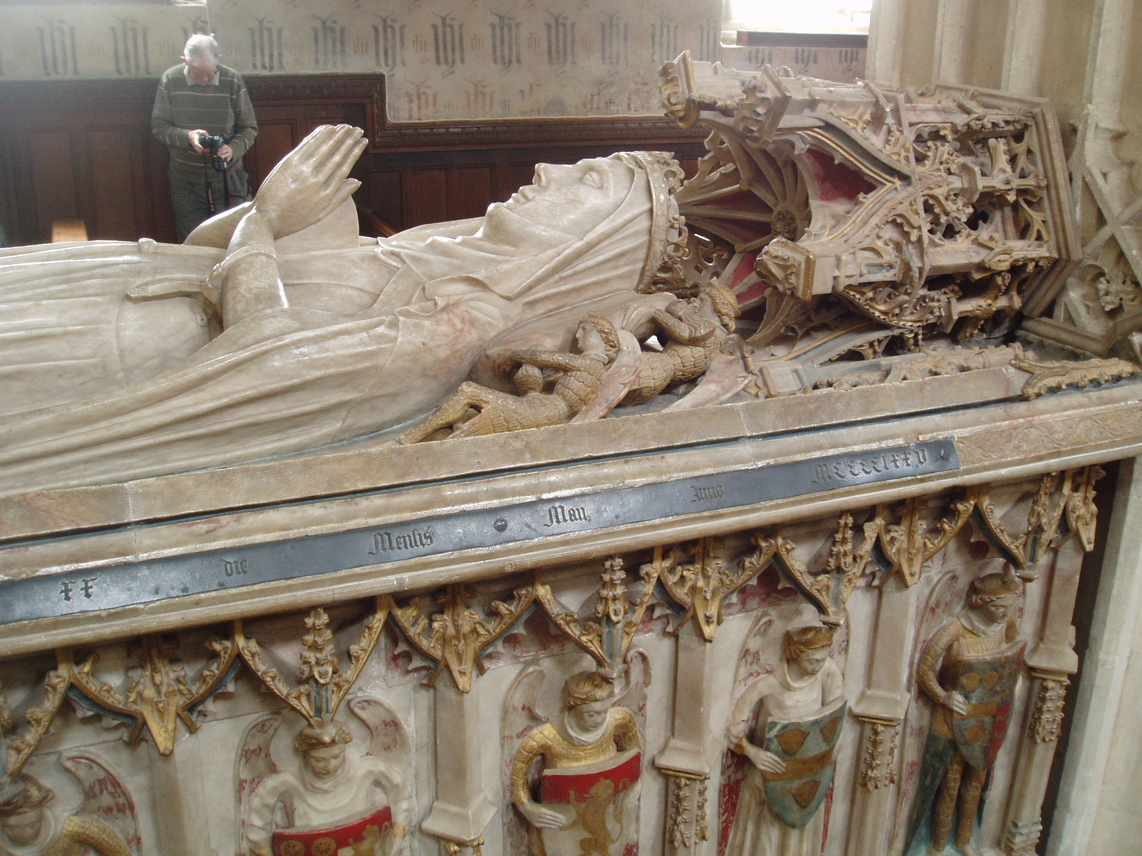 Duchess of Suffolk's Tomb, Ewelme Ewelme is distinguished by it's unique surviving complex of medieval buildings, church, almshouses and school, all dating from the 1430s and all still functioning. The benefactors were William and Alice de la Pole, the Duke & Duchess of Suffolk who once had a palace nearby. Alice was also the grand-daughter of Geoffrey Chaucer, and lies buried under one of the finest medieval monuments in England in the church she rebuilt in 1432. The church of St Mary the Virgin in Ewelme is one of the most rewarding parish churches, the star attraction is the Duchess of Suffolk's splendid tomb, erected in 1475, under a canopy south of the altar. She lies in her earthly finery, but below is a memento mori, her cadaver effigy, viewed through openings beneath the row of shield-bearing angels on the tomb chest. The condition of the monument is exceptional, no small thanks to the doors having been locked to 17th century puritan vandals. There are other fine sculpured details around the church and a magnificent 15th century panelled ceiling to the south chapel, carved with angels. The east window here also contains a medley of 15th century stained glass fragments collected from various windows. Another outstanding feature is the font, also from 1475 which is dominated by it's angel-capped spire-like wooden cover, over 10ft high and raised by a pulley carved like a tudor rose.