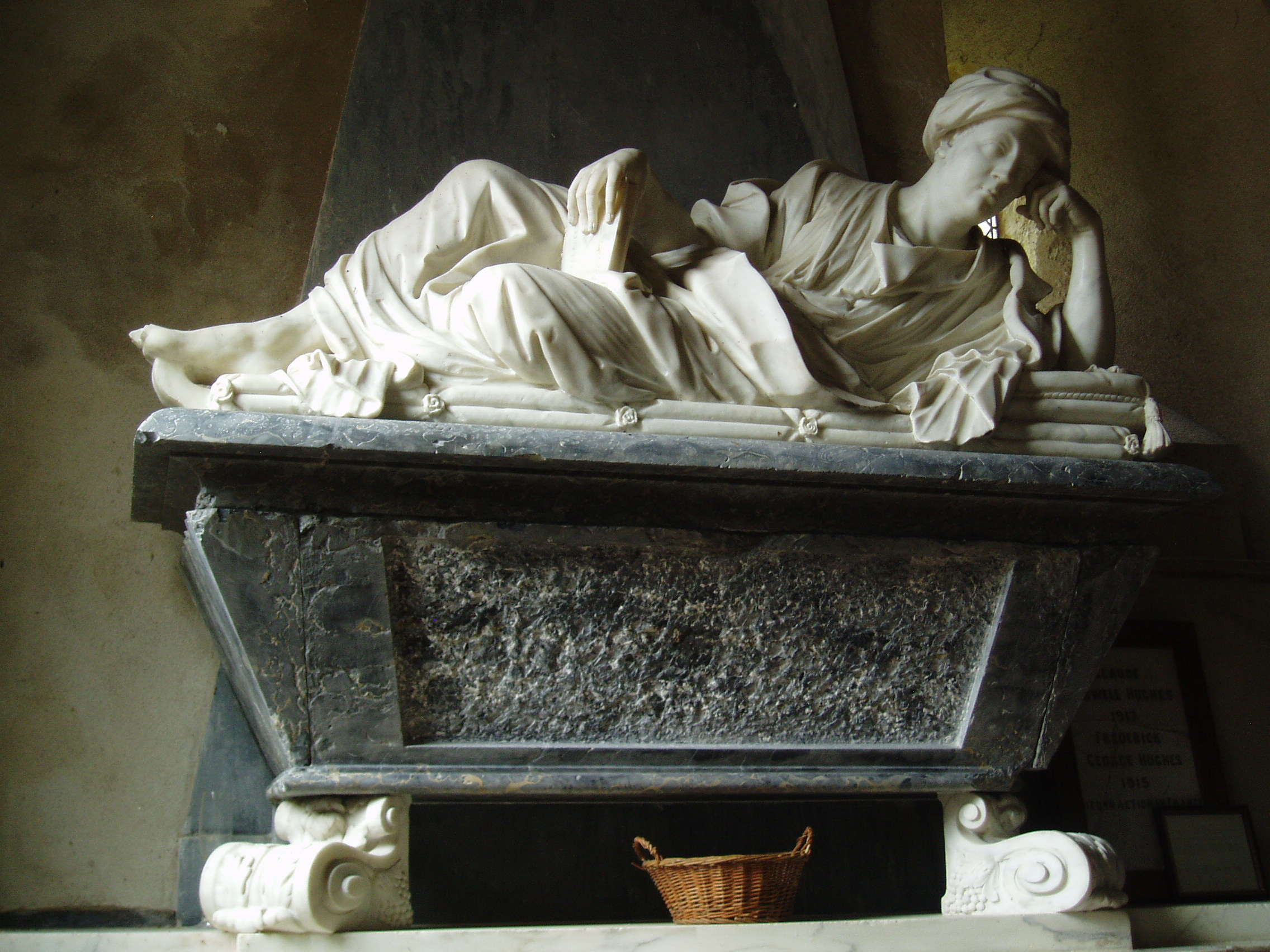 John Sanders Monument, Mongewell Located in an idylic riverside setting, St John the Baptist in Mongewell has faced a long decline following redundancy in the early 20th century, which has left the nave as a most picturesque romantic ruin. The church was formally Norman (as echoed by the very restored apse) but was mostly remodelled in 1791 when an unusual apsed west end with a polygonal turret were added. After a long dereliction the nave roof collapsed in the 1940s, resulting in the present partition blocking the chancel arch, separating the surviving chancel from the ruined nave. The chancel now contains the font and monuments, formerly located at the west end of the nave, to preserve them from the elements. The font is neo-Norman Victoriana whilst the monuments are finer Baroque pieces, one a tablet with busts to Edmund Madock and his wife from 1692 and the larger one a sarcophagus with a finely sculpted effigy in a turban of John Sanders from 1731. The church is now vested in the Churches Conservation Trust; a key is available for access to the interior of the chancel.