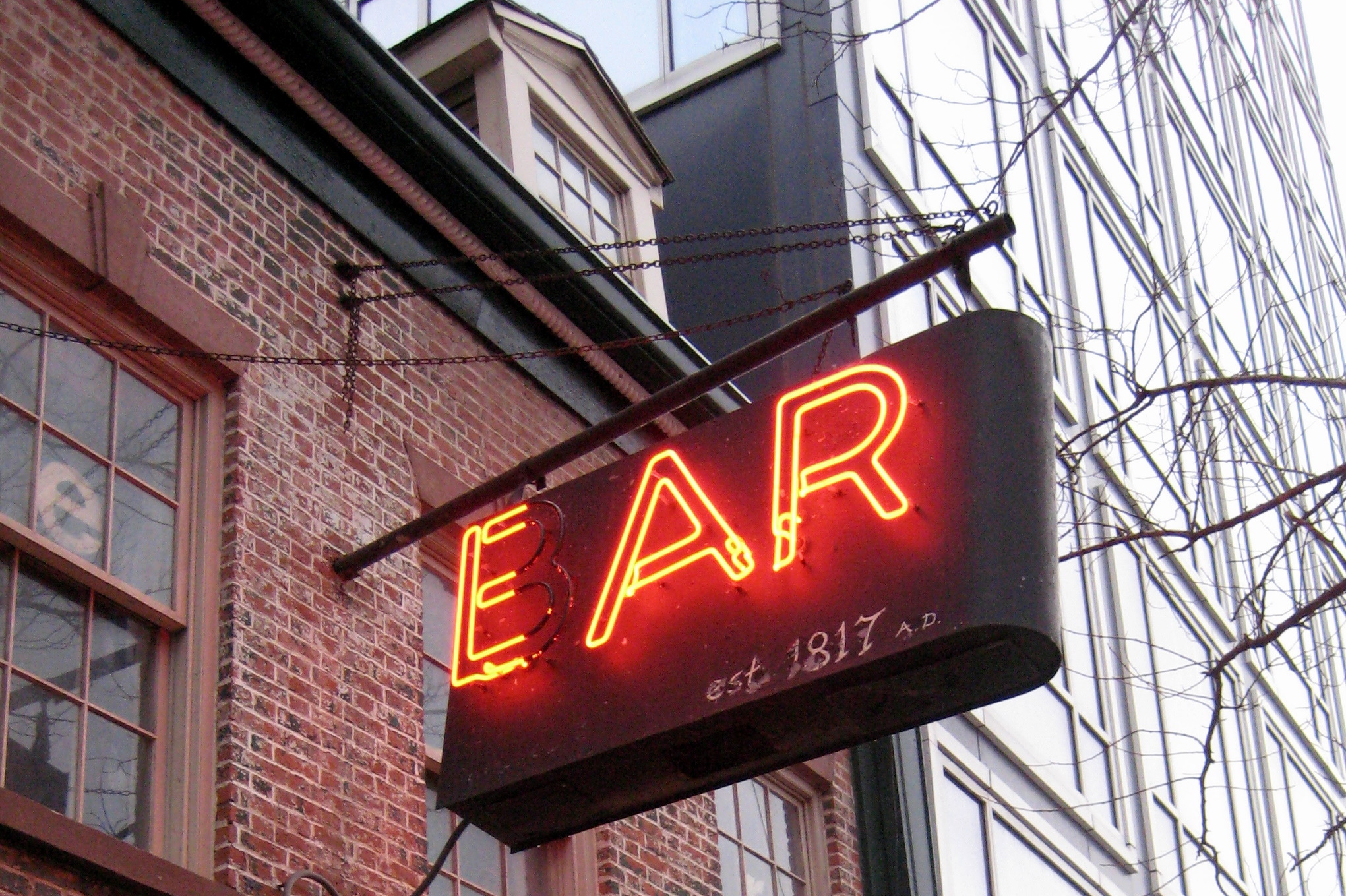 NYC - SoHo - Ear Inn The Ear Inn, a small landmark Irish pub/restaurant at 326 Spring Street, has been serving up drinks since 1867 in an 1817 house built for James Brown. James Brown, an African American who aided George Washington during the American Revolution is reputed to be depicted in Emmanuel Leutze's Washington Crossing the Delaware. After the war, Brown settled in New York and worked in the lucrative tobacco trade between the South and Europe. He was successful enough to move to the suburbs near the village of Greenwich, and build this fashionable Federal townhouse, which was at the time, only five feet from the original shoreline of the Hudson River. The land was part of Jan’s Calk Hook Farm near the mouth of Minetta Creek flowing from Washington Square. Down Spring Street at today’s Avenue of the Americas stood the elegant Richmond Hill Estate, once home of George Washington as President, and later the residence of John Adams and Aaron Burr. The James Brown House is one of very few Federal houses left in the City. It is in largely original condition of 2 1/2 stories with dormers, double splayed keystone lintels, and a gambrel roof. The construction is all wood post and ‘beams set with pegs, with a facade of Flemish bond brick. The restaurant doors and window are late 19th century. The panel to the right of the main door is a night shudder cover to the original shop window, an 18th century style feature unique to this building. Once there were cellar windows and fireplaces in the bar area. At some time mid 19th century, this building became a spiritual establishment. Thomas Cooke brewed beer and sold crocks of corn, whiskey to thirsty sailors. The bottles above the bar and jugs above the phone booth were all dug out of the basement below the dining room. This area was once a backyard for a garden and an outhouse. A back alley extended to Washington Street near the canal and flower market on Canal Street. The dining room was constructed when the brewery became a restaurant at the turn of the century. Later it was a speakeasy during Prohibition. The upstairs apartment was variously a boarding house, smuggler’s den, and brothel. Ghosts have been heard and seen, in particular one “Mickey,” a sailor still waiting for his clipper ship to come in. Since the liberation from Prohibition, the bar had no name. To the sailors and longshoremen, it was like a clubhouse and was known as “The Green Door.” Its motto from long ago was “Known from Coast to Coast.” There used to be a pool table, gambling, tall tales, and no music except the sea songs of the bar room buddies. No women were allowed. Then in 1977, new resident-owners christened the place the Ear Inn. The new name was chosen to avoid the Landmark Commission’s lengthy review of any new sign. The neon’ BAR sign was painted to read EAR, after the musical Ear Magazine published upstairs. Ol’ timers never noticed and still call the place the Green Door. National Register of Historic Places #83001717 (1983)