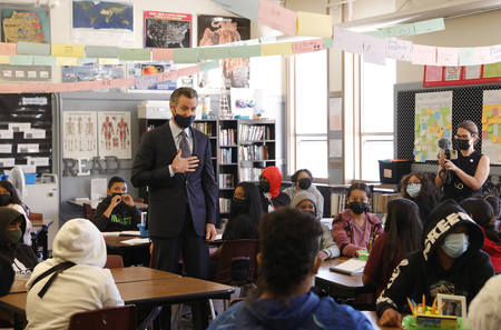 Gov. Gavin Newsom talks with masked seventh-graders in a California school