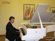 Пианист за белым концертным роялем на мероприятии