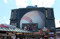 Atlanta - Turner Field: 3M Photograph of Hank Aaron's 715th Ball The 3M Photograph of Hank Aaron's 715th Ball, located on the back of BravesVision in The Plaza at Turner Field, was taken by photographer Arrington Hendley. The concept for the monumental 100-foot graphic was was developed by David Ashton, a Baltimore-based artist and designer and it was produced by the Arrington Group, an Atlanta commercial photography studio. Henry "Hank" Aaron hit his 715th career home run. which barely cleared the left field wall, off the Los Andeles Dodgers' Al Downing, on April 8, 1974, in front of a homefield crowd of 53,775 people. Aaron had entered the 1974 season just one home run behind Babe Ruth's career record of 714 home runs, but quickly caught up on April 4th at Riverfront Stadium in Cincinnati. Turner Field originally opened as the 85,000-seat Centennial Olympic Stadium in 1996 to serve as the centerpiece of the 1996 Summer Olympics, after which it was converted into a 49,000-seat baseball park. Since 1997 it has served as the home of the Atlanta Braves of Major League Baseball.