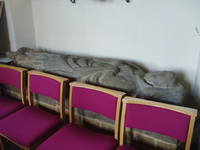 Priest's Effigy Though mostly a 19th century rebuilding St Peter's at Kineton is one of the most attractive buildings in South Warwickshire. The tower alone survives of the medieval building with an impressive 13th century doorway at it's base and a 15th century top with an elaborate restored parapet. The rest of the building was rebuilt by Sanderson Miller in 1755 and again in 1873-89, all in a beautifully warm toffee coloured ironstone. The church is entered from the west through an unusual tunnel (from 1755) in the base of the tower. Inside the fittings are mostly from the late 19th century rebuilding, with some delicate glass by Powell's of Whitefriars in the chancel. A few 18th century tablets line the walls but the most significant item is the (sadly worn) 14th century effigy of a priest in the north aisle.