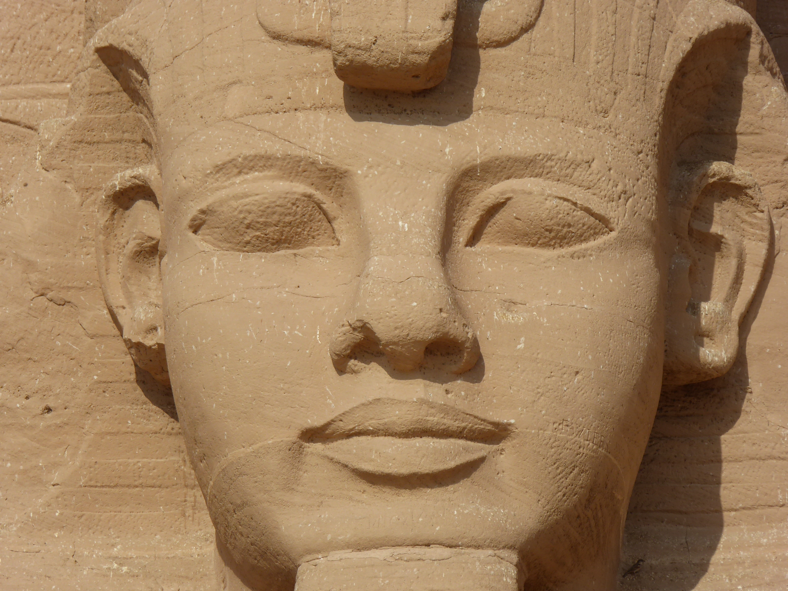 Ramesses II, Abu Simbel The rock-cut temples of Abu Simbel are one of Egypt's greatest wonders, and the most powerful testimony to the ambition of the country's greatest Pharaoh, Ramesses II. The visitor cannot fail to be impressed by the sheer spectacle of it all, there is simply nothing else quite like standing before these awe-inspiring colossi hewn from the living rock. The temples were carved in the 19th Dynasty (c1264-44 BC) at the height of the long reign of Ramesses II (also known as Ramesses the Great) at a remote location along the Nile close to Egypt's southern border in Nubia (close to the border of modern-day Sudan), doubtless to serve as a statement of Pharaonic power to Egypt's southern neighbours. Any visitor travelling northwards would have passed these wonders and have immediately known who was in charge! The temples also serve as Ramesses's offering to the gods, though deities are easily forgotten amidst his own omnipresent likenesses. The more famous main temple featuring the four seated colossi of Ramesses is dedicated to the gods Ptah, Amun and Ra-Horakhte, along with Ramesses deified self, the whole edifice serving as his own apotheosis. The interior of the temple culminates with (sadly mutilated) carved figures of all four, which are illuminated by the Sun on two separate days of the year. The facade is dominated by the two pairs of Ramesses colossi, each with smaller figures of queens and princesses alongside or between their legs. The upper half of one of the great figures collapsed in antiquity, pieces of the head and crown remain lying on the ground below. In the centre within a niche above the entrance stands the falcon-headed Sun-god Ra-Harakhte (large in itself though dwarfed by Ramesses) but even the act of placing a deity at the centre of the facade serves the cult of the Pharaoh, since the god holding an User-staff and a figure of the goddess Maat enables the statue to symbolise Ramesses's coronation-name 'User-Maat-Re'. Within the temple lies an impressive pillared hall, each column again bearing the likeness of Ramesses, this time in standing figures in the pose of Osiris. Reliefs show the king before the gods and a large chariot scene from the battle of Kadesh. Various side rooms contain more humbly finished reliefs whilst the final room is the sanctuary with the gods' images described above. To the right of the temple of Ramesses stands the smaller temple dedicated to his favourite wife, Queen Nefertari (nominally dedicated to the goddess Hathor whose image is carved on the columns within). The facade is adorned with six standing figures in deeply-splayed niches, four more of Ramesses himself and the remaining two of Nefertari, and unusual prominence for a queen. The temples are often best remembered for their dramatic rescue during the 1960s when the construction of the Aswan High Dam threatened to submerge them completely. Many Nubian temples were relocated at this time to save them from the rising waters, but none more famous than Abu Simbel, where the unique rock-cut nature of the monuments complicated the rescue. After several options where explored a decision was made to slice the temples into hundreds of movable sections and relocate both to higher ground immediately above their former positions. Between 1964-8 a massive international effort saw the entire rock-face removed and the components of the temples re-erected before two artificial mountains above, each supported by a hollow concrete dome. The engineering feat involved is every bit as impressive as the temples themselves. Today Abu Simbel is one of the greatest sights of Egypt, though its remoteness requires either a flight or a long three-hour drive south of the nearest city, Aswan. It is worth every effort to reach it, and once seen it is never forgotten. en.wikipedia.org/wiki/Abu_Simbel_temples