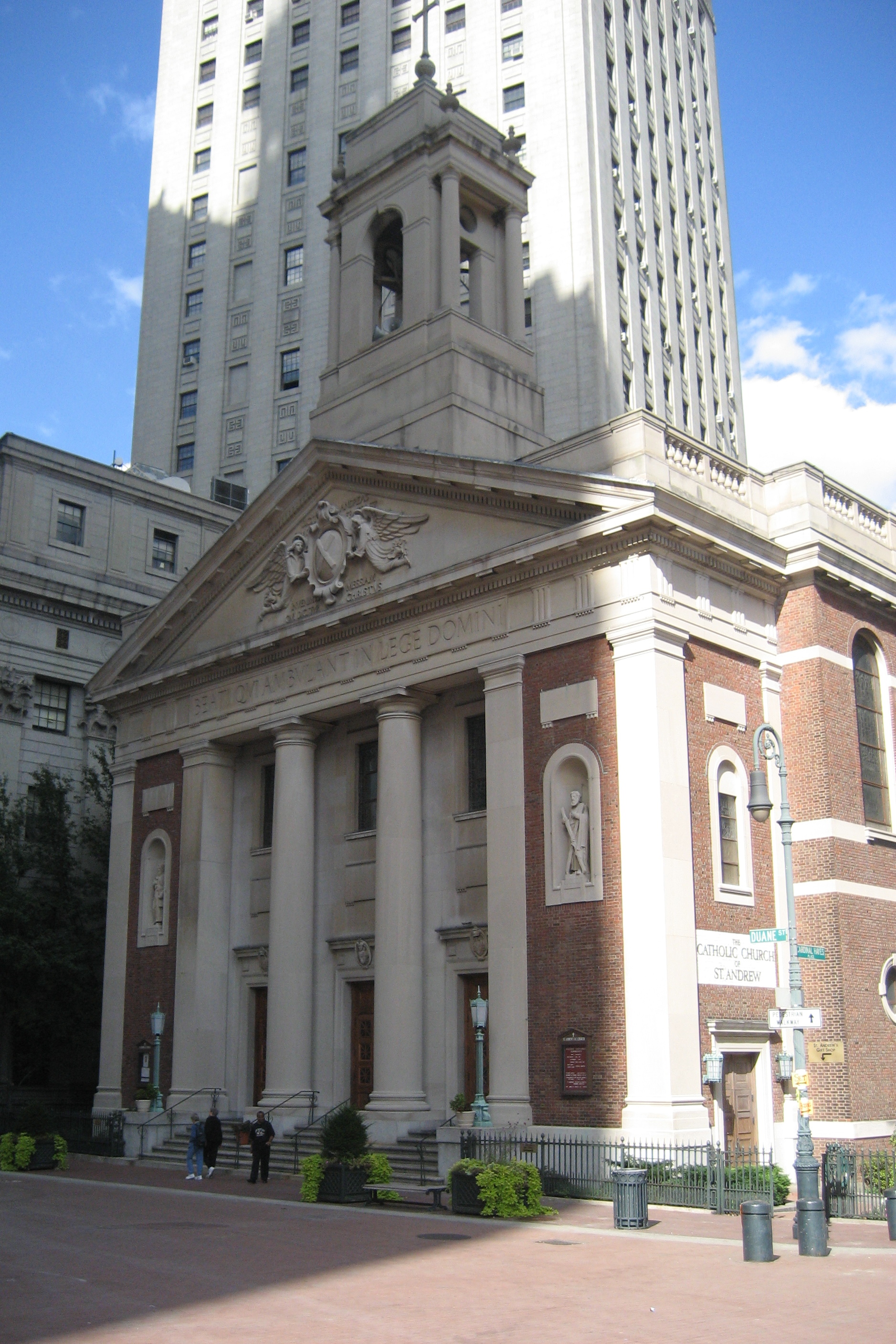 NYC - St. Andrew's Church St. Andrew's Church was consecrated in 1939, replacing an earlier church, named Carroll Hall, built in 1842. Just before the Civil War when the City Hall area became the center of the printing and newspaper industry, the church recevied special dispensation to say a "Printer's Mass"at 2:30 A.M. for the night shift of newsmen and printers. It later became the first parish church to offer noon mass for the growing number of businessman in the area. The Latin phrase in the frieze means "Blessed are those who walk in the law of the Lord."