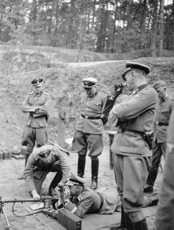 Рейхсфюрер СС Генрих Гиммлер (Heinrich Himmler) практикуется в стрельбе из пулемета MG 34. Cлева адъютант Гиммлера - оберштурмфюрер Иоахим Пайпер (Joachim Peiper). 1939 год.
