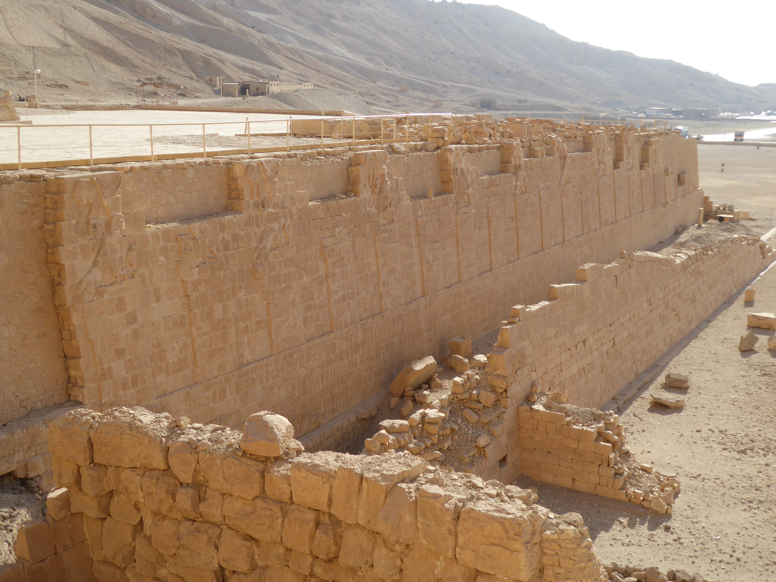Hatshepsut Temple, Deir el Bahri Queen Hatshepsut's mortuary temple at Deir el Bahri is one of the most remarkable architectural achievements of ancient Egypt. Set into the base of the cliffs of the west bank opposite Luxor, the monument is as impressive for its setting as it is for its strikingly 'modern' design. The temple was built by Egypt's most celebrated female pharoah, Queen Hatshepsut (c1507-1458BC) in the early years of the 18th Dynasty. The site chosen adjoined the much earlier mortuary temple of Montuhotep II and far surpassed it in scope. The temple takes the form of three raised terraces with colonnades containing reliefs, extolling both the virtues of Hatshepsut and commemorating the trading routes she established into the horn of Africa in the land of Punt. The open courtyards before the temple were once alive with gardens, including exotic plants brought back to Egypt from the aforementioned expeditions to Punt. Today the temple has regained much of its former splendour through careful reconstruction work in the latter half of the 20th century. The topmost level (still under restoration on our last visit in 1992) is now open and dominated by several colossal figures of Hatshepsut in the form of Osiris (she is generally depicted with all the trappings and attire of a male pharoah, her face alone hinting at her feminine nature). Much of the statuary was destroyed under her successor Thutmosis III (who felt usurped by Hatshepsut in his younger years) and reconstructed from fragments. Whilst many later pharoahs built their own mortuary temples nearby, none came close to matching Hatshepsut's vision and it remains one of the most unique monuments of the ancient world. For more see below:- en.wikipedia.org/wiki/Mortuary_Temple_of_Hatshepsut