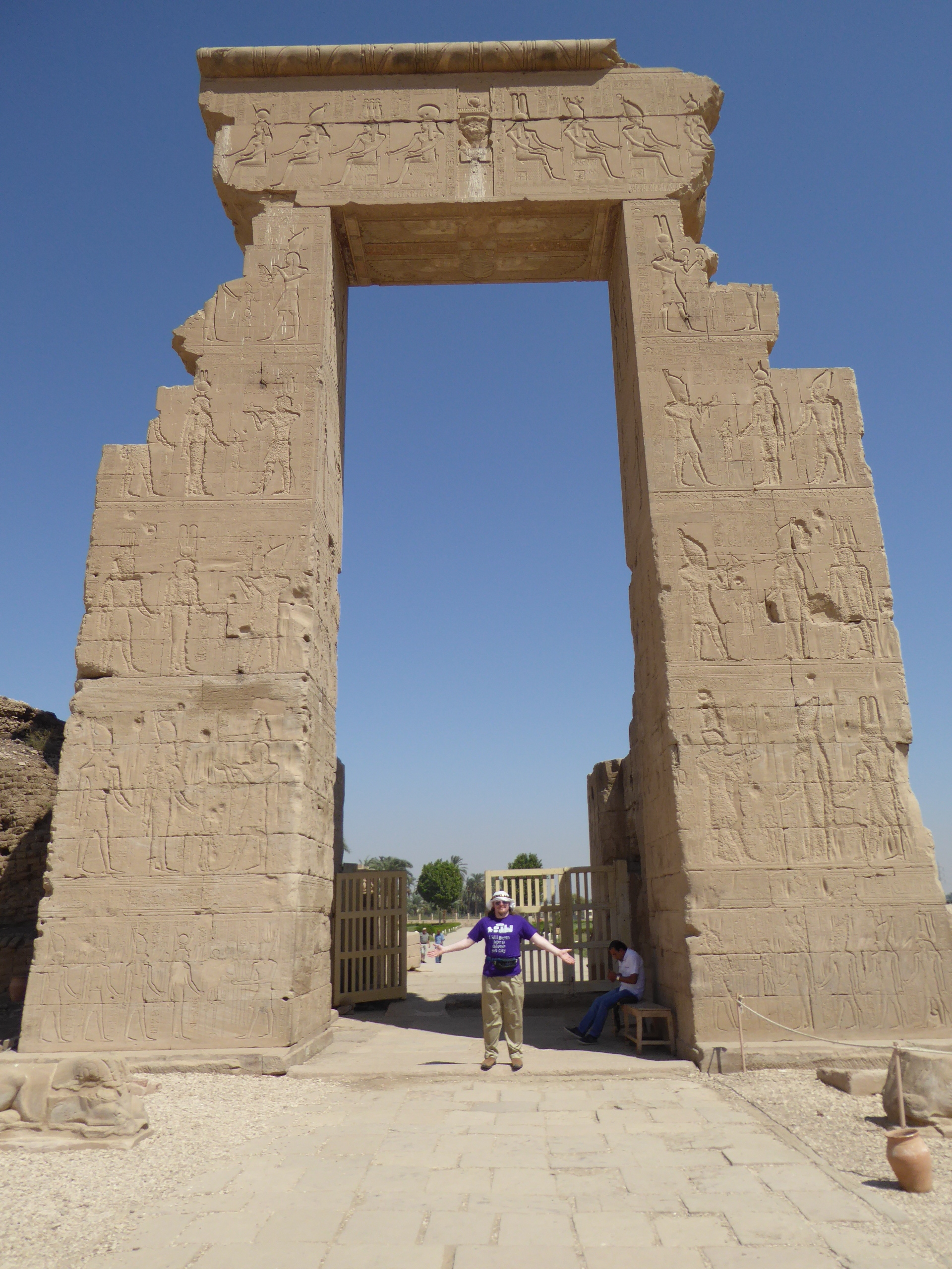 Temple Gateway, Dendera The Temple of Hathor at Dendera is one of Egypt's best preserved and most beautiful ancient shrines. This magnificent edifice dates to the Ptolemaic period, late in Egyptian history, though the site long had been the cult centre for the goddess Hathor for centuries before (the earliest extant remains date to c360BC but a temple is recorded here as far back as c2250BC). Most of the main building dates to the reigns of the last Cleopatras and further decoration and building work within the complex continued in the Roman period up to the reign of Trajan. The dominant structure in the complex is the Temple of Hathor, an enormous structure with a rectangular facade punctuated by the Hathor-headed columns of the hypostyle hall within. This hall is an architectural wonder, a masterpiece of ancient Egyptian design and decoration, which covers every surface and has been recently cleaned, revealing a superb astrological ceiling in all its original vibrant colours. Sadly there was much iconoclasm here during the early Christian period and most of the reliefs of the walls and pillars have been defaced. Worse still is the damage to the 24 Hathor-head capitals: not one of the nearly a hundred huge faces of the goddess that once smiled down on this hall has been left unblemished, most with their features cruelly chiselled away. The main temple building is otherwise structurally intact, and extends into further halls and chapels beyond, again with much relief decoration (much of which is again defaced). In one corner is an entrance to a crypt below, an unusual feature in Egyptian temple architecture consisting of several narrow passages adorned with carved relief decoration in good condition. There are further sanctuaries and chapels above on the roof of the temple, accessed by a decorated staircase and including the room where the famous Dendera Zodiac was formerly located (today its place in the ceiling taken by a cast of the original, now displayed in Paris). The highest part of the roof complex is no longer accessible to tourists, but I can still recall making the ascent there on our first visit in 1992. Several other buildings surround the main temple, the most impressive of which is the mammisi or 'birth-house'. This consists of a large rectangluar hall surrounded by a colonnade near the entrance to the site and has some well preserved relief decoration on its exterior. Most of this structure dates to the Roman period, but the ruins of its predecessor built under Nectanebo II (Egypt's last native pharoah) stand nearby. Dendera temple is one of the most rewarding in Egypt and shouldn't be missed. It is one of the most complete and evocative ancient monuments in the country and its recent restoration has revealed a surprisingly extensive amount of colour surviving within (we were amazed by the dramatic contrast with the soot-blackened ceiling we'd beheld on our previous visit in the 1990s). Despite its relative youth (in Egyptian terms at least!) it is easily one of my favourite sites in Egypt. en.wikipedia.org/wiki/Dendera_Temple_complex