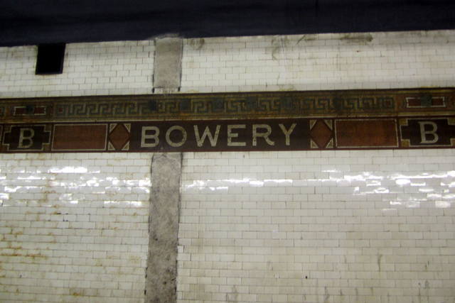 NYC - LES: Bowery Station Bowery, a New York City subway station on the BMT Nassau Street Line located at the intersection of the Bowery and Delancey Street, is served by the J train at all times and the Z train rush hours in the peak direction. Opened on August 4, 1913, it features 4 tracks--2 in revenue service, and 2 island platforms. Bowery, commonly called The Bower is the name of both a street and a small neighborhood. Bowery is an anglicisation of the Dutch bouwerij, derived from an antiquated Dutch word for "farm." In the 17th century the road branched off Broadway north of Fort Amsterdam at the tip of Manhattan to the homestead of Peter Stuyvesant, Director-General of New Netherland. As a street, the Bowery was known as Bowery Lane prior to 1807. Today it runs from Chatham Square in the south to Cooper Square at 4th Street in the north.