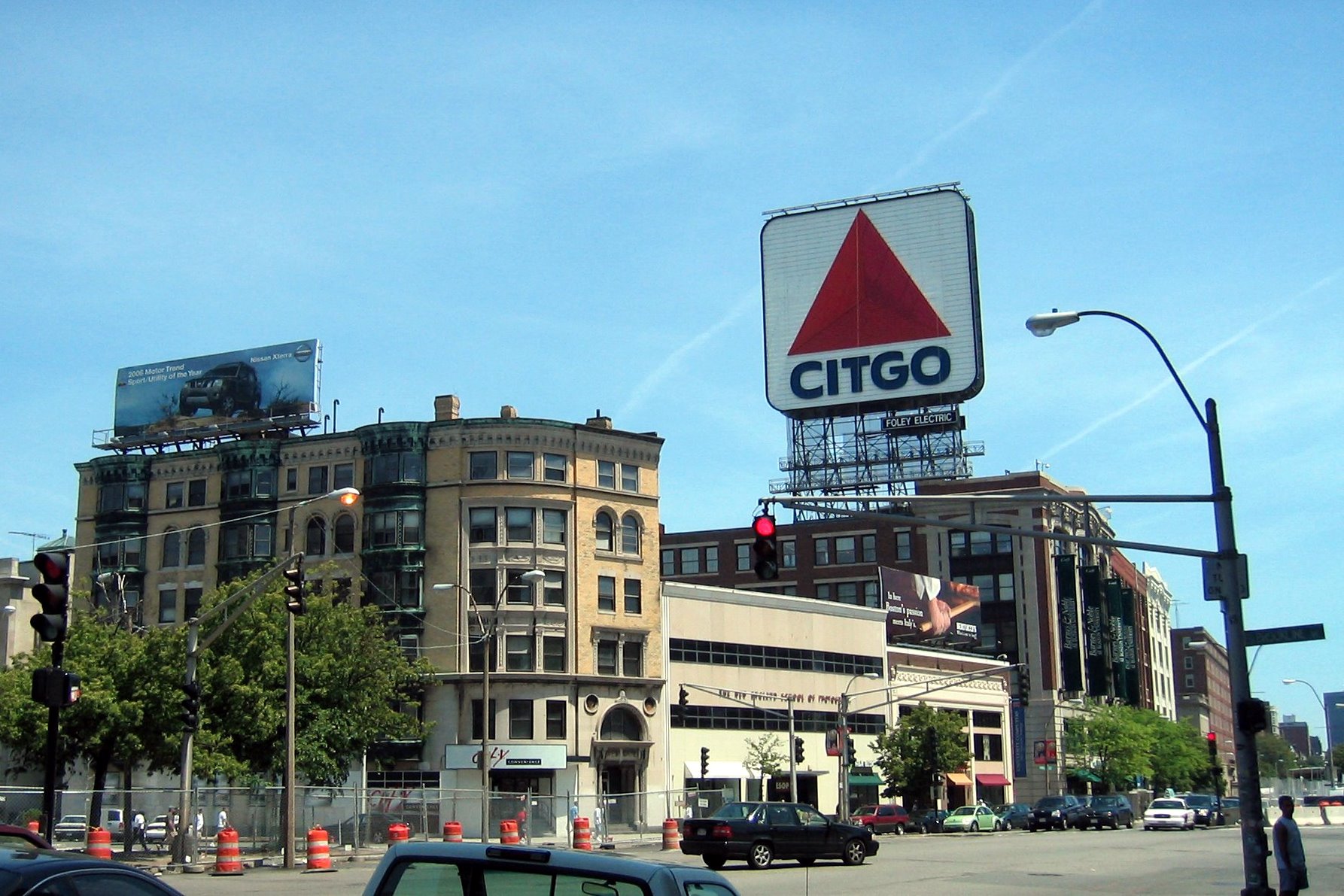 Boston - Kenmore Square: Citgo Kenmore Square exists at the intersection of several Beacon Street, Commonwealth Avenue and Brookline Avenue, abutting Boston University and serving as a transportation hub for nearby Landsdowne Street and Fenway Park. The large, double-faced sign featuring the Citgo "trimark" logo has become a landmark, partly because of its visibility over the Green Monster during televised Red Sox games. The current 60 ft x 60 ft incarnation, unveiled in March 2005 after a six-month restoration project, features thousands of light-emitting diodes (LEDs). LEDs were selected for their durability, energy efficiency, intensity, and ease of maintenance. Earlier versions featured neon lighting; the previous sign contained some 5,878 glass tubes with a total length of over five miles. The first sign, featuring the Cities Service logo, was built in 1940, and replaced with the trimark in 1965. In 1979 Governor Edward J. King ordered it turned off as a symbol of energy conservation. Four years later, Citgo attempted to disassemble the weatherbeaten sign, and was surprised to be met with widespread public affection for the sign and protest at its threatened removal. The Boston Landmarks Commission ordered its disassembly postponed while the issue was debated. While never formally declared a landmark, it was refurbished and relit by Citgo in 1983 and has remained in operation ever since. Citgo is now a subidiary of Petróleos de Venezuela S.A. and in 2006, Jerry McDermott, a Boston city councillor, proposed that the sign be removed in response to Venezuelan President Hugo Chavez's insults toward America . McDermontt also suggested draping an American flag or Boston Red Sox banner over the sign until Chavez is out of office.