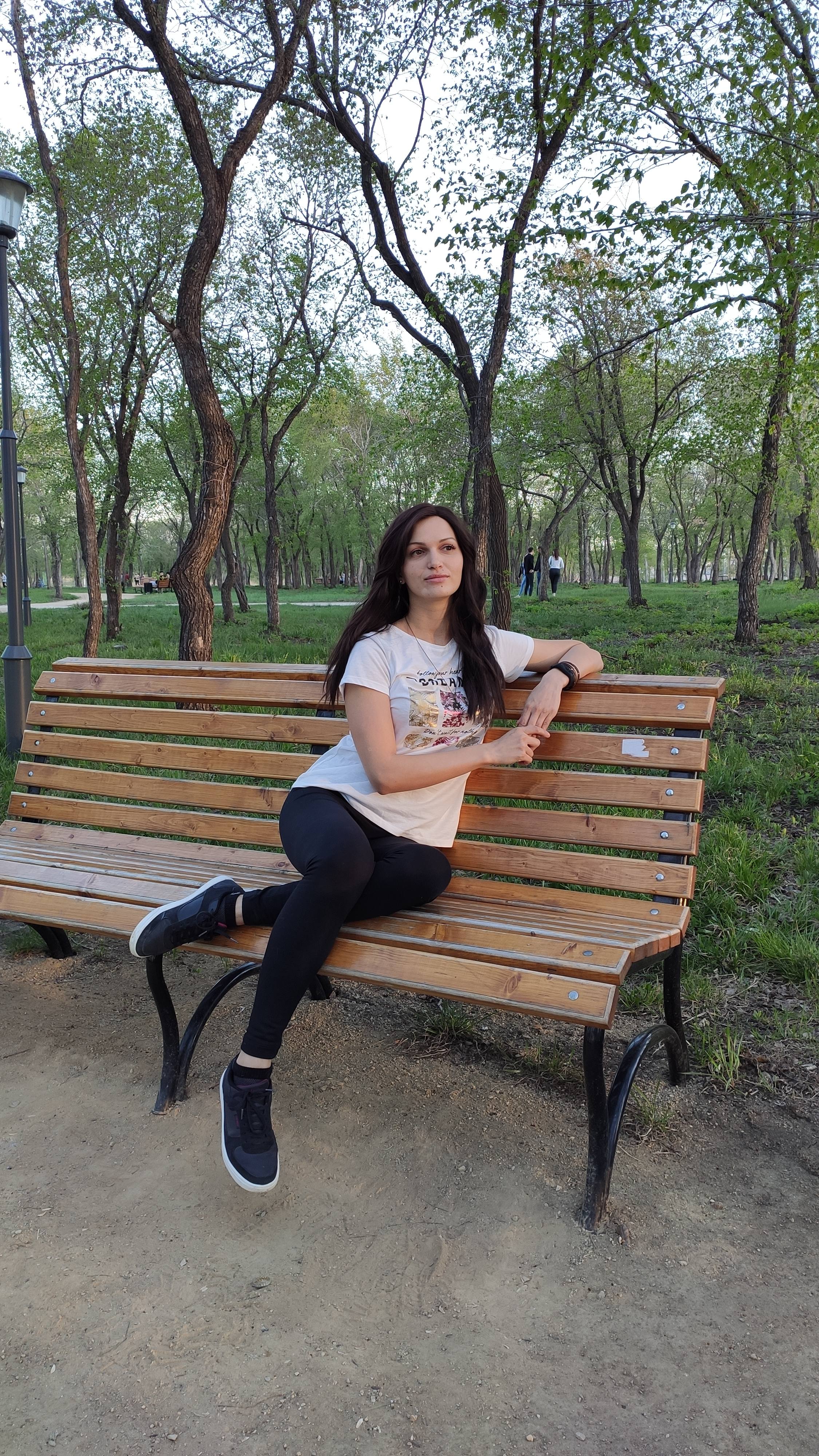 Красивая девушка на скамейке в парке